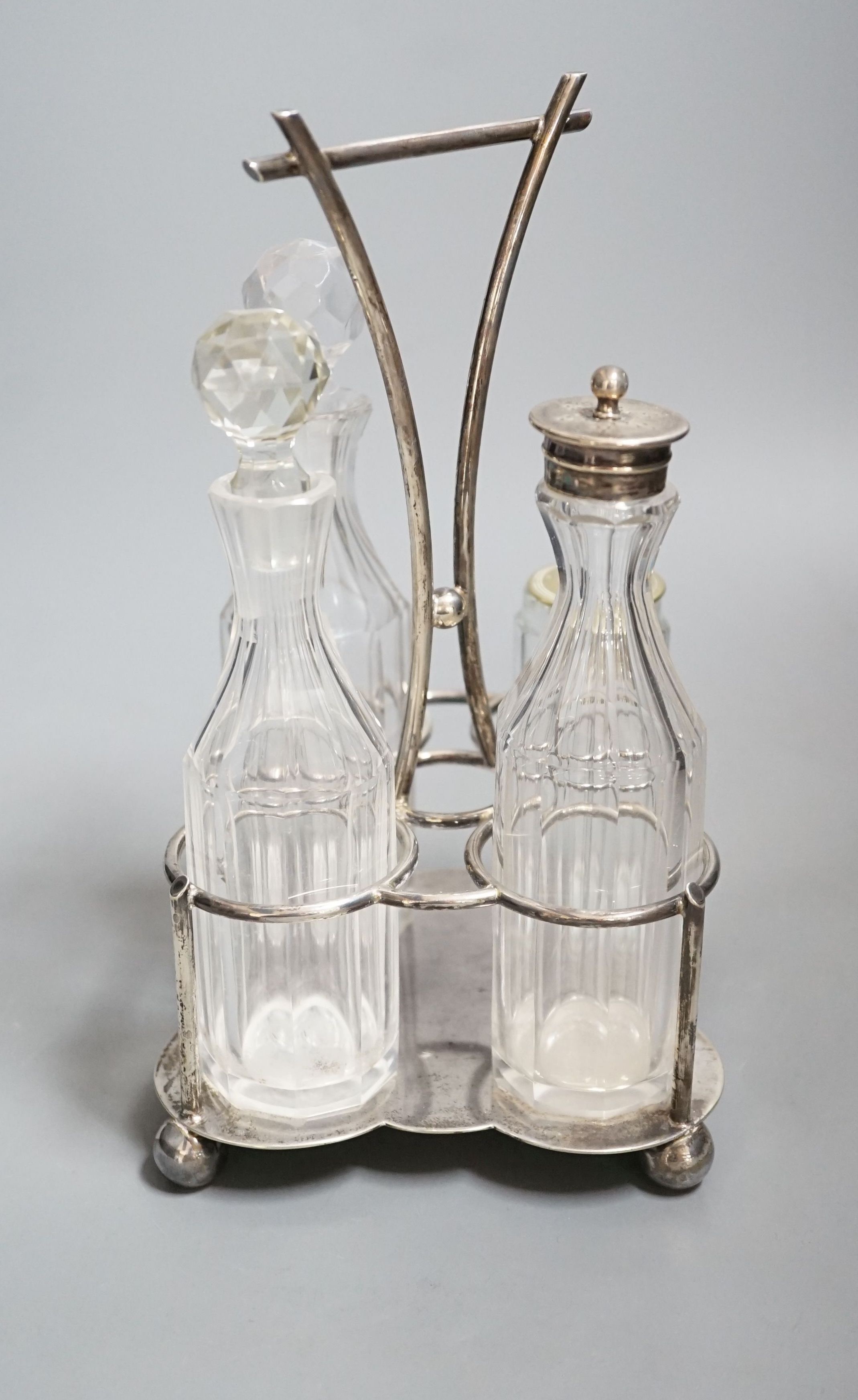 A George V silver four division cruet stand, Cooper Brothers & Sons, Sheffield, 1918, together with four glass cruets, one with silver mount and one associated, height 23.9cm, 13.50z.